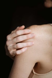 Schulter einer jungen Frau im Schatten. Sie ist dünn, doch leidet sie unter Magersucht? Magersucht Anzeichen Gesicht und allgemeine Anzeichen